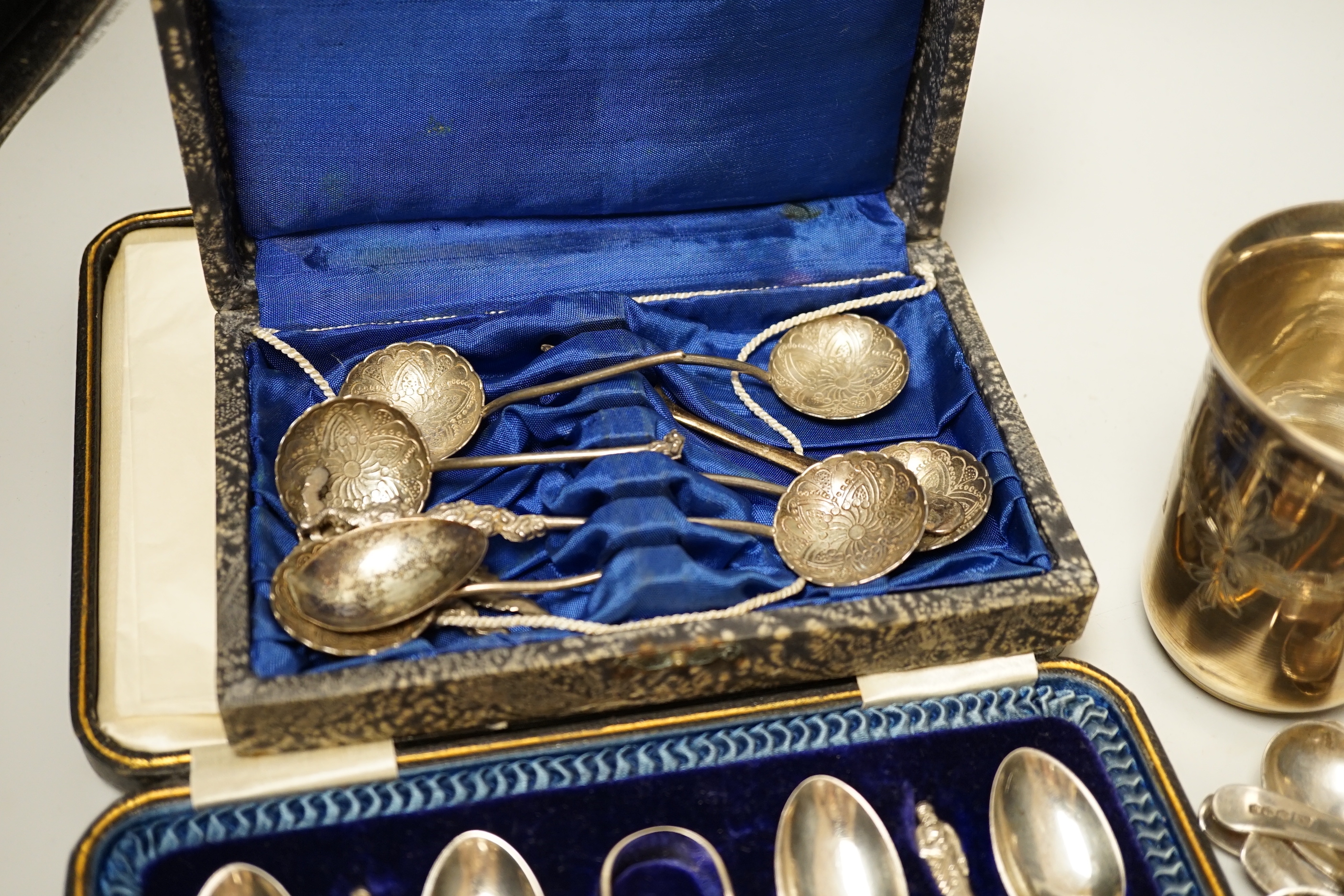 A pair of engraved white metal tumblers, stamped 'K980', four Russian 84 zolotnik spoon, a cased set of silver silver teaspoons with tongs, two silver napkin rings and other minor silver and white metal flatware.